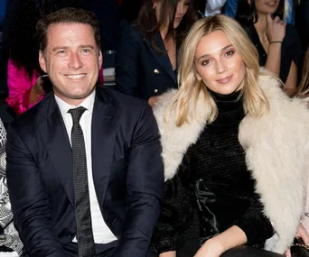 Couple seated together at a formal event, smiling at the camera.