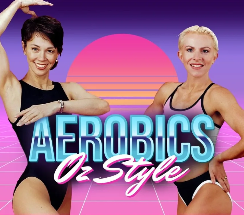 "Two women in aerobics outfits posing against a retro-themed 'Aerobics Oz Style' background with a sunset graphic."