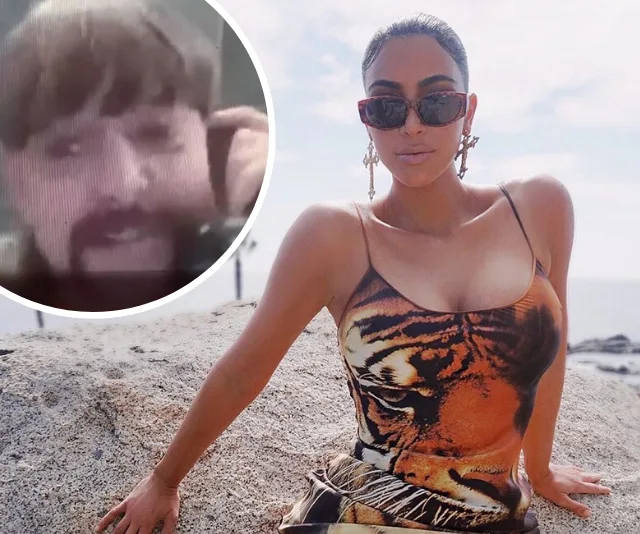 Woman in sunglasses and tiger print dress sits on rock; inset shows a person with a mustache in a video call.