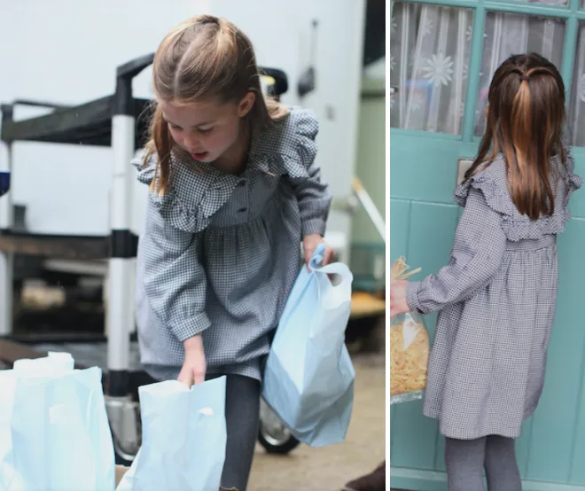 Young girl in a checked dress and ponytails, carrying shopping bags and reaching for a door handle.