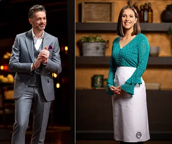Two individuals in a culinary setting; one in a suit, the other in a green top with an apron.
