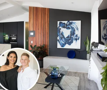 Living room with abstract painting and plants; inset of a smiling couple hugging.