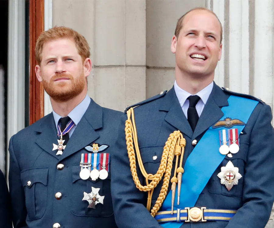 Two men in formal military uniforms standing together, both wearing medals and decorations, looking attentively.