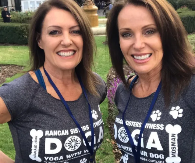 Rancan Sisters smiling outdoors, wearing matching "DOGA" fitness shirts with lanyards.