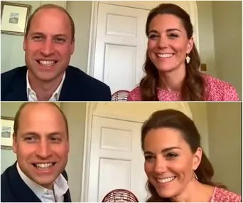Smiling couple during a video call, sitting in front of a door with a bingo cage visible.
