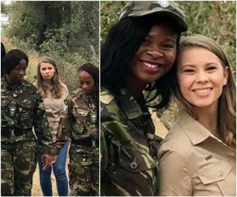 Bindi Irwin and Black Mambas team members in uniform walking and posing in a natural setting.
