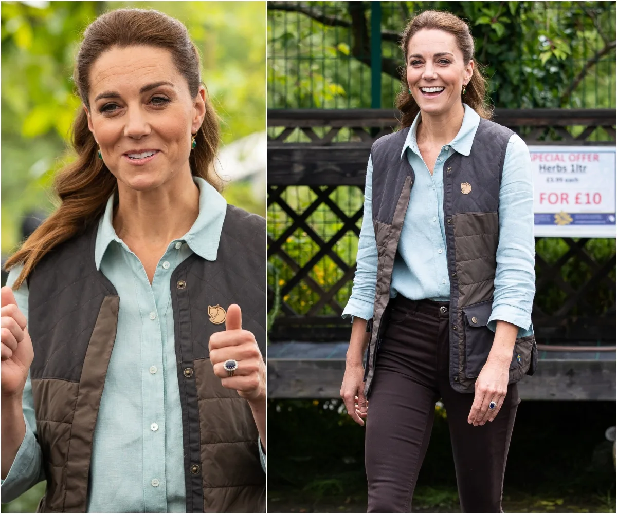 Woman in a garden center wearing a light blue shirt and brown vest, smiling while outdoors.