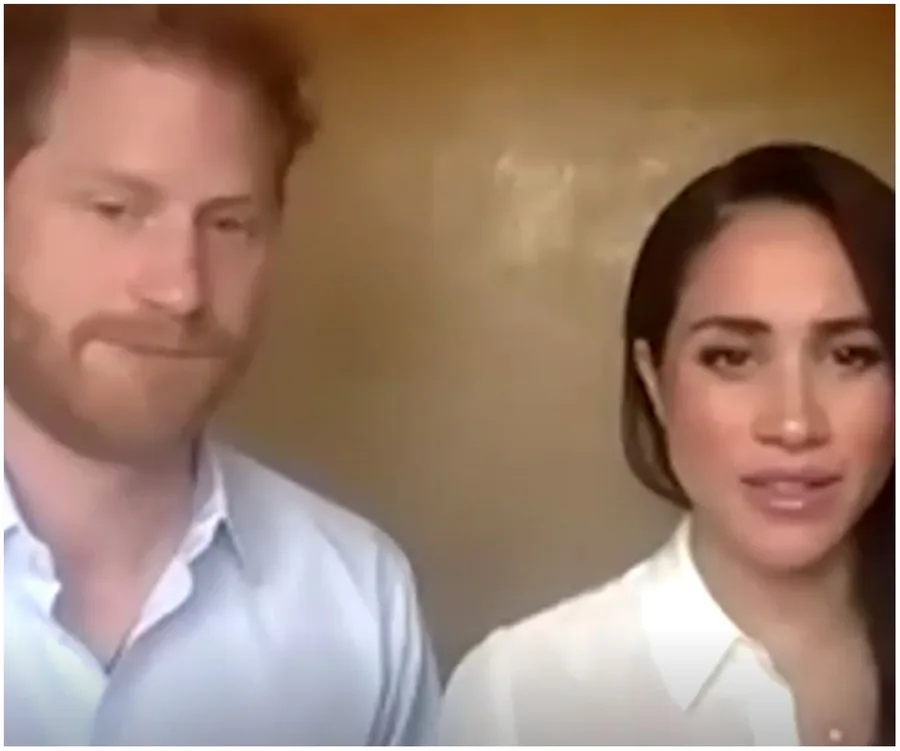 Prince Harry and Meghan Markle on a video call in a softly lit room, both wearing white shirts.