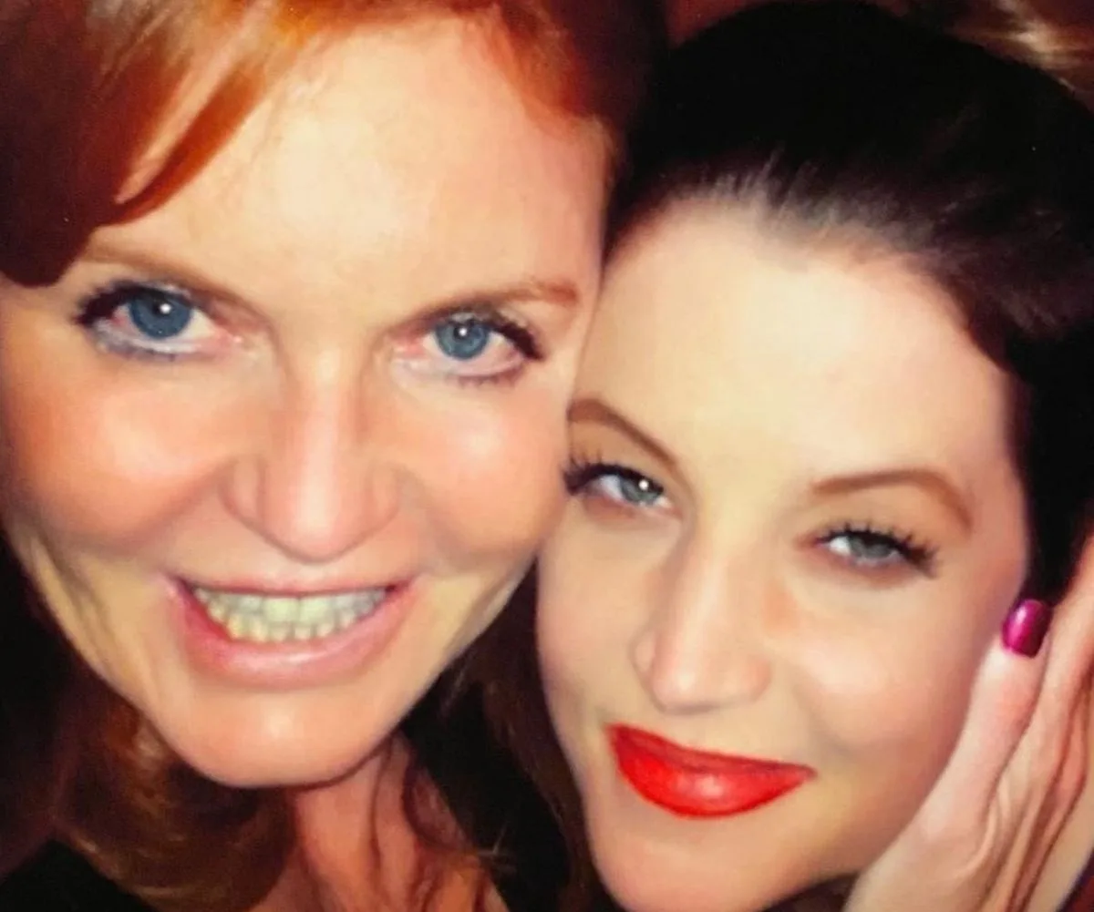 Two women smiling closely in a selfie with bright eyes and lips.
