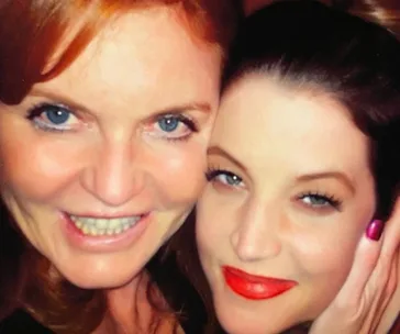 Two women smiling closely in a selfie with bright eyes and lips.