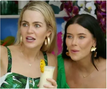 Two women from Bachelor in Paradise Australia 2021 looking surprised, one holding a tropical drink.