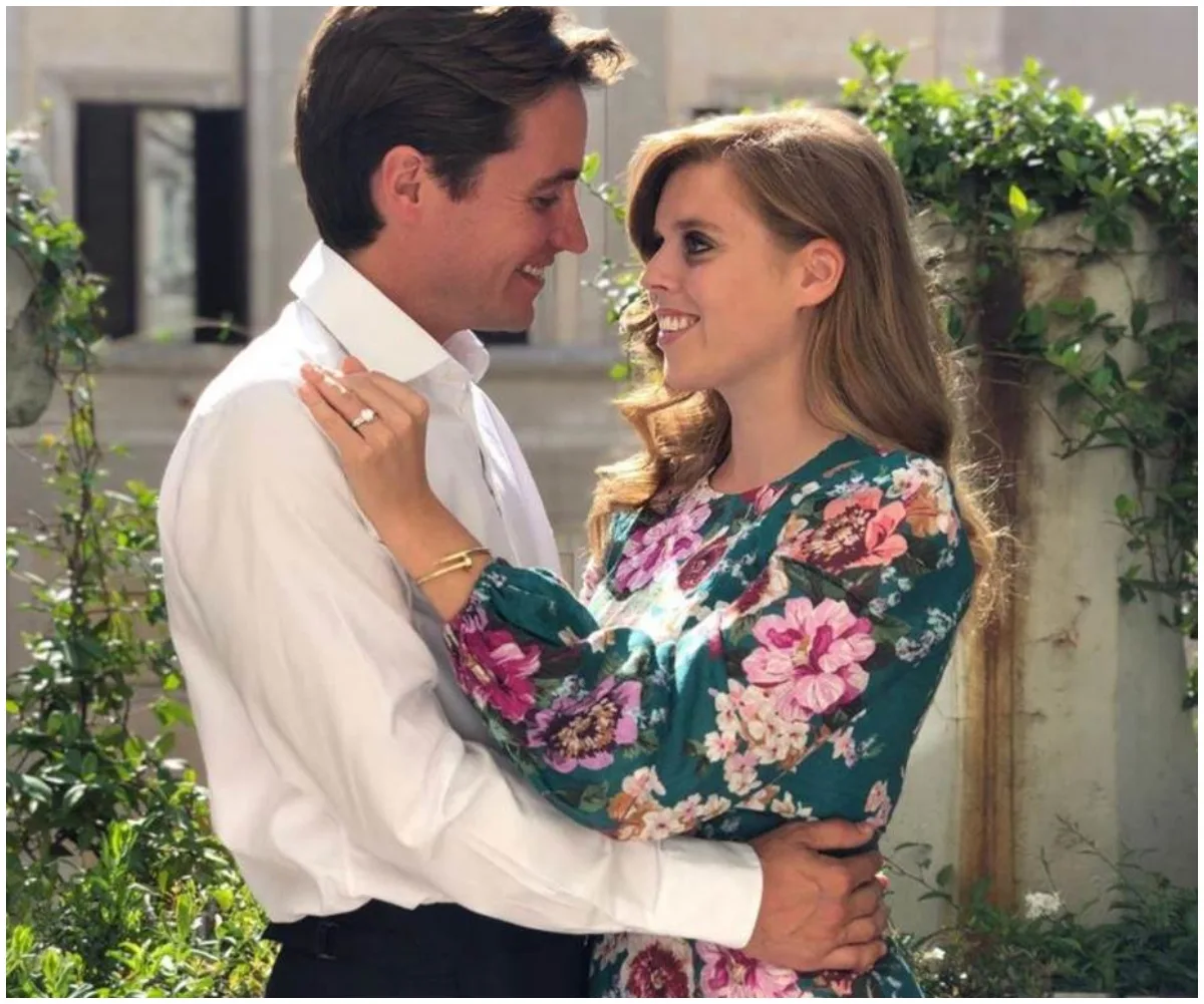 Couple embracing in a garden, smiling at each other lovingly.