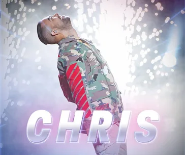Contestant performing on stage with lights and sparks, wearing a camouflage jacket, with the name "Chris" in bold letters below.