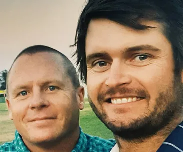Two people smiling in a close-up outdoor selfie.