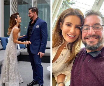 Alt text: "Couple posing elegantly in formal attire and smiling for a selfie indoors."