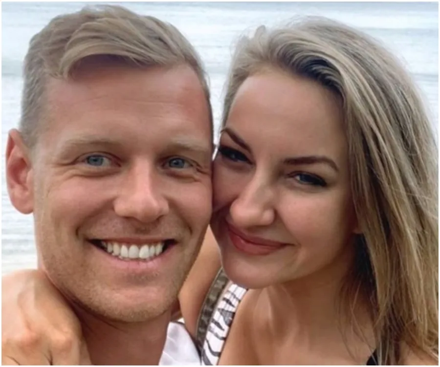 A happy couple smiling together by the sea.