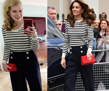 Two women wearing matching striped tops and navy pants with red clutches.