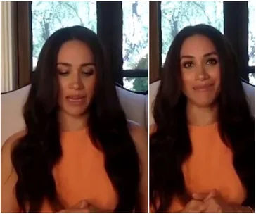 Meghan Markle in an orange top, speaking in a video call with a window and trees in the background.