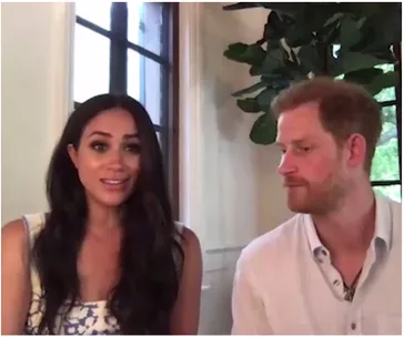 Two people sitting indoors, with greenery and a window in the background.
