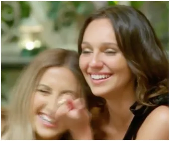 Two women laughing together, appearing joyful and engaged in a light-hearted moment.