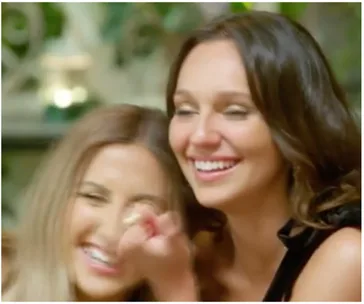 Two women laughing together, appearing joyful and engaged in a light-hearted moment.