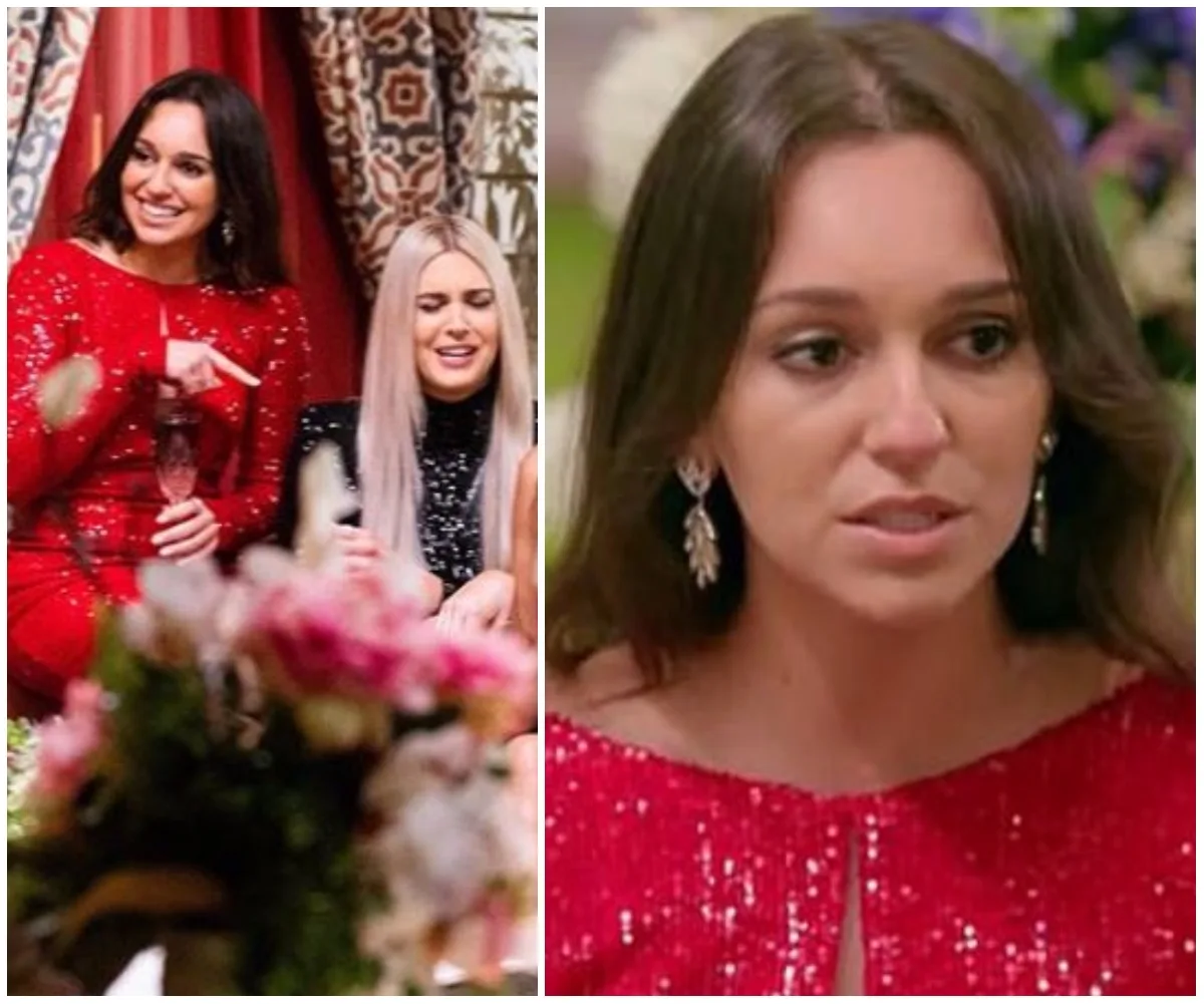A woman in a sparkling red dress with long earrings sits indoors, smiling, while another woman nearby has a surprised expression.