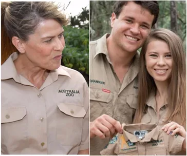 Terri Irwin in Australia Zoo shirt; family holding baby outfit labeled Australia Zoo, smiling outdoors.