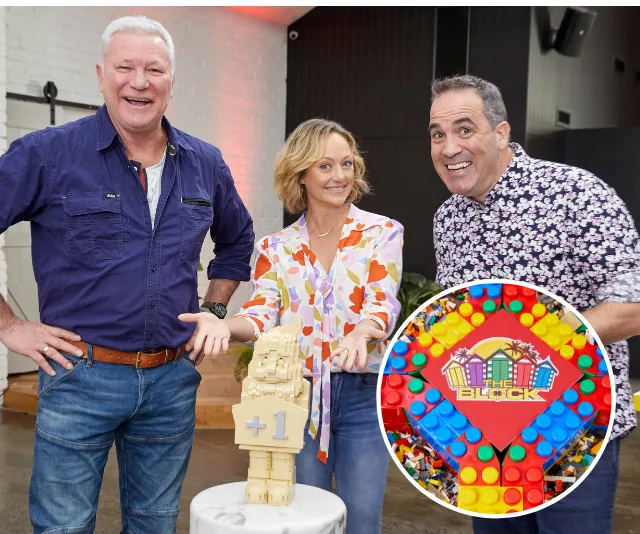Three people smiling with a LEGO trophy, featuring "The Block" logo, on a table.