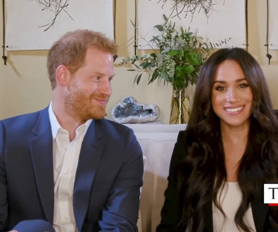Alt text: "A couple sitting together, smiling during a talk, with plants in the background."