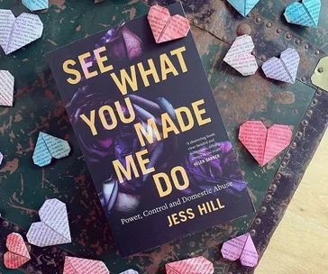 Cover of "See What You Made Me Do" by Jess Hill, surrounded by origami hearts on a distressed green surface.