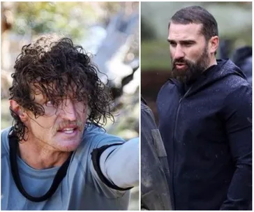 "Two men outdoors in intense discussion, one with curly wet hair, other with a beard, both in rugged outdoor gear."