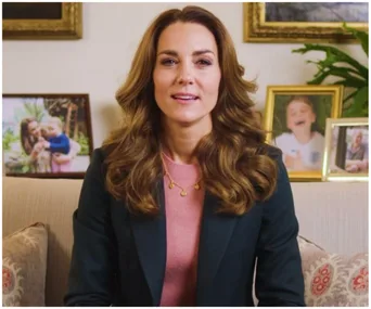 Kate Middleton delivering a video message, seated on a sofa with family photos in the background.