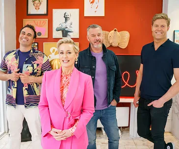 Four smiling presenters pose in a colorful, art-filled living room during a Christmas special.