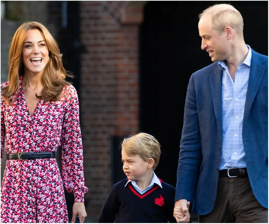 A woman in a floral dress, a man in a blue blazer, and a young boy smiling and walking together outdoors.