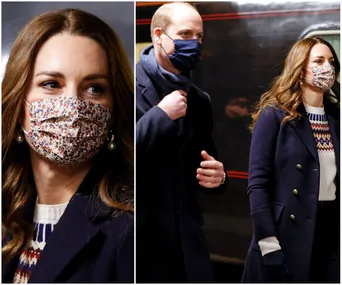Royal couple wearing masks and dark coats during a train tour visit.