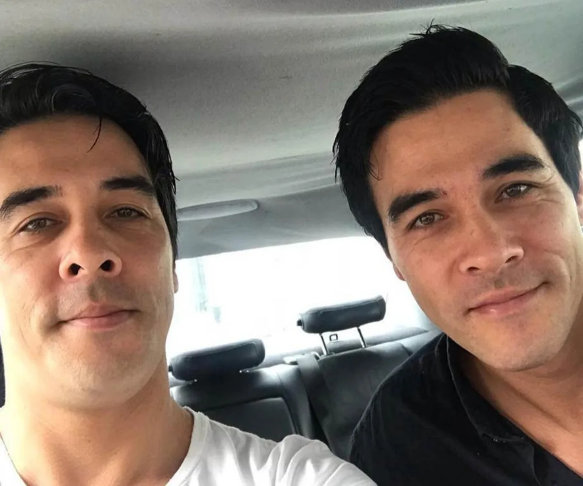 Two men in a car, smiling at the camera.