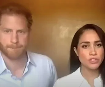 Two individuals in a video call, one with red hair, wearing a light shirt, and the other with long dark hair, also in a light shirt.