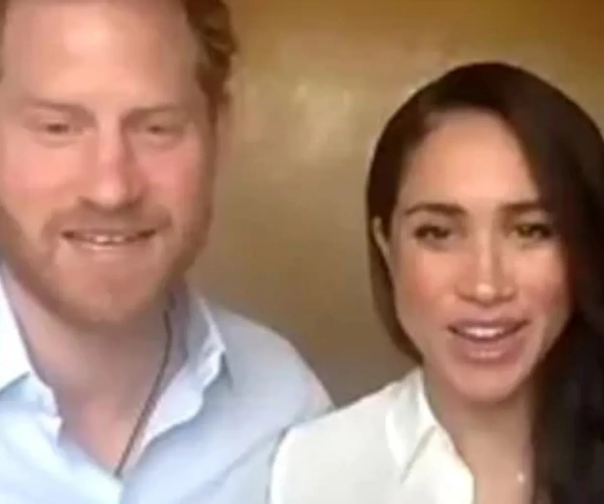 A man and woman smiling in a casual setting, wearing light-colored shirts.