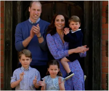 A family of five clapping outside, with parents in back, children in front; the mother holds the youngest child.