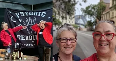 Two women in red jackets; one in front of a psychic reading banner, another taking a selfie near the Newcastle bridge.