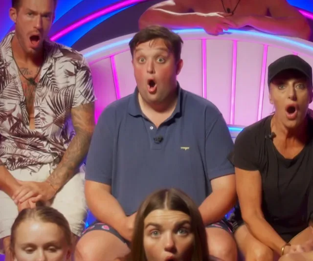 Group of surprised individuals sitting in a brightly lit room on "Big Brother Australia 2021."