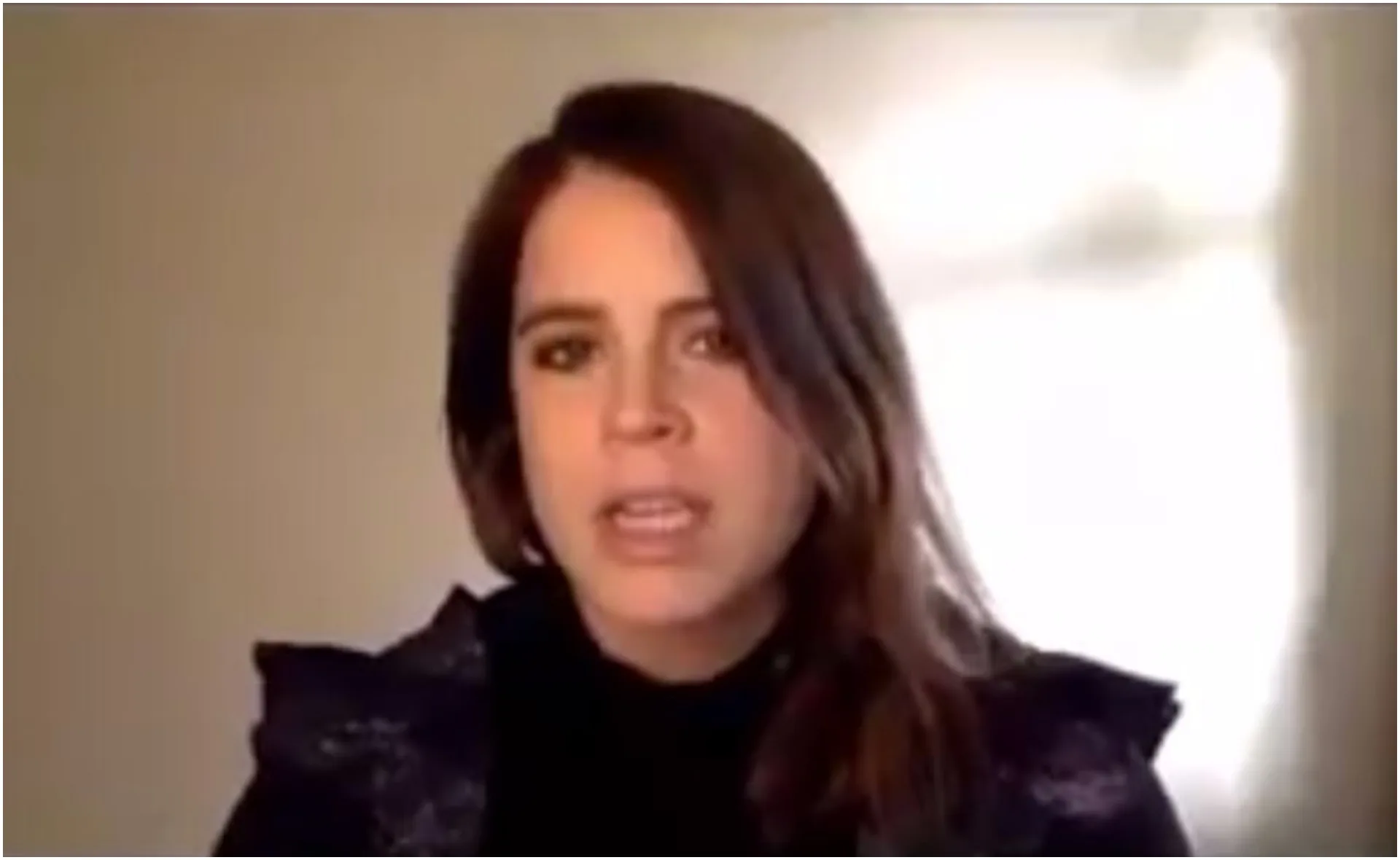 Chat during a video call, woman with brown hair speaking against a neutral background.