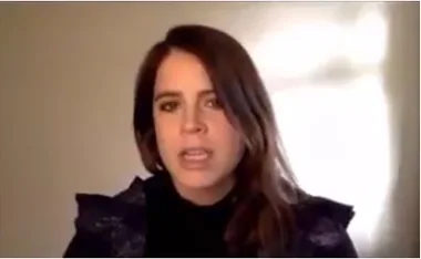 Chat during a video call, woman with brown hair speaking against a neutral background.