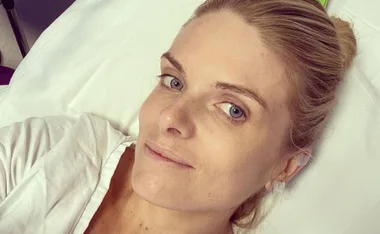 A woman lying in a hospital bed, looking relaxed and comfortable.