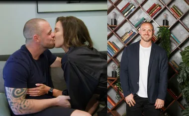 A couple kisses on a couch; the man smiles in a blazer next to a bookshelf with plants.