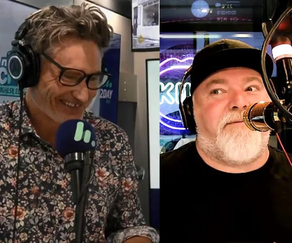 Radio hosts laughing and speaking into microphones in a studio setting, one wearing floral and glasses, the other in a cap.