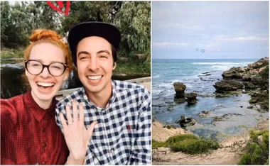 Couple smiling with engagement ring by a river; coastal rocky shore with ocean waves in the background.