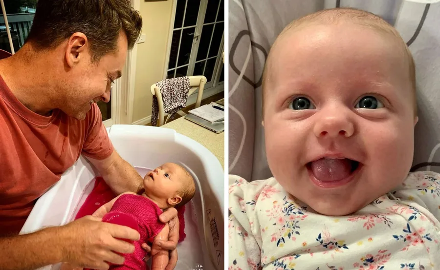 Father bathing baby; close-up of smiling baby in floral onesie.