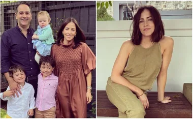 Family of five posing outdoors; woman sitting on a bench in casual attire, smiling.