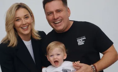 A happy family photo with a smiling man, woman, and a cheerful baby wearing matching t-shirts.